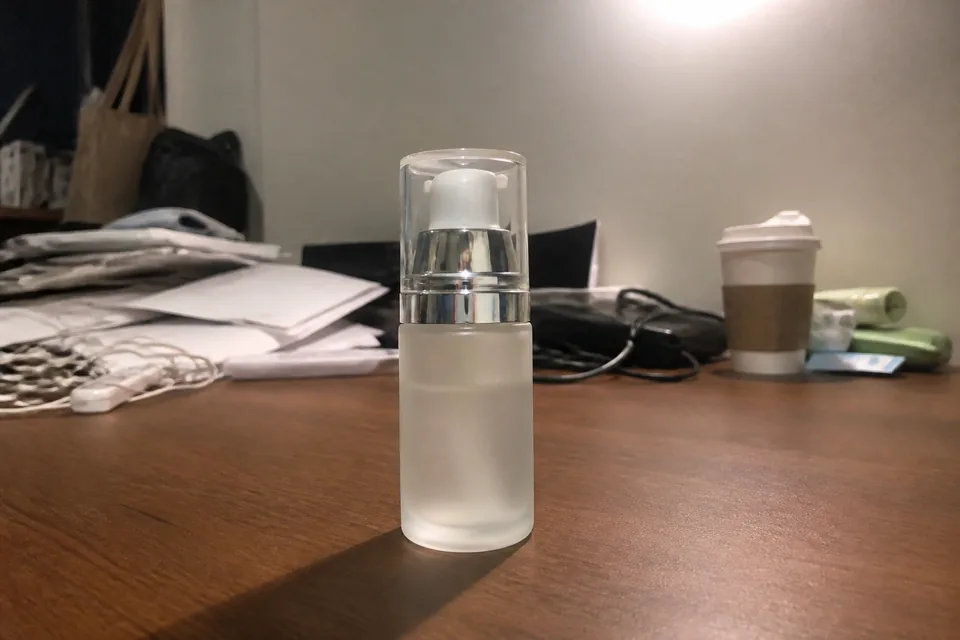 Flacone cosmetico in vetro su una scrivania disordinata