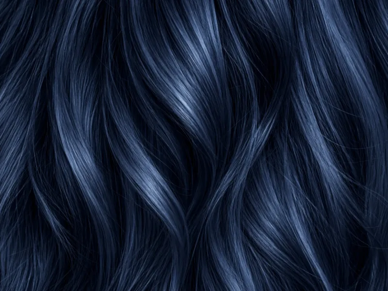 Close-up of blue-black hair strands with a cool blue shine.