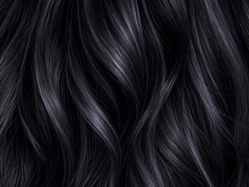 Close-up of raven black hair strands with a violet shine.